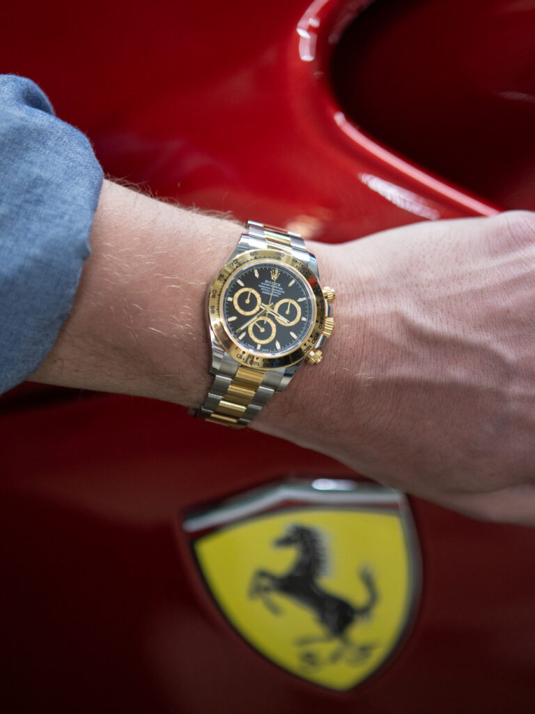 Rolex Daytona 126503 black dial in front of Ferrari